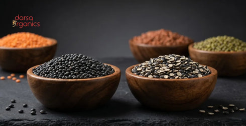 Organic black lentils (urad dal whole and split with skin) with other lentil varieties displayed in wooden bowls, showcasing natural unpolished organic pulses